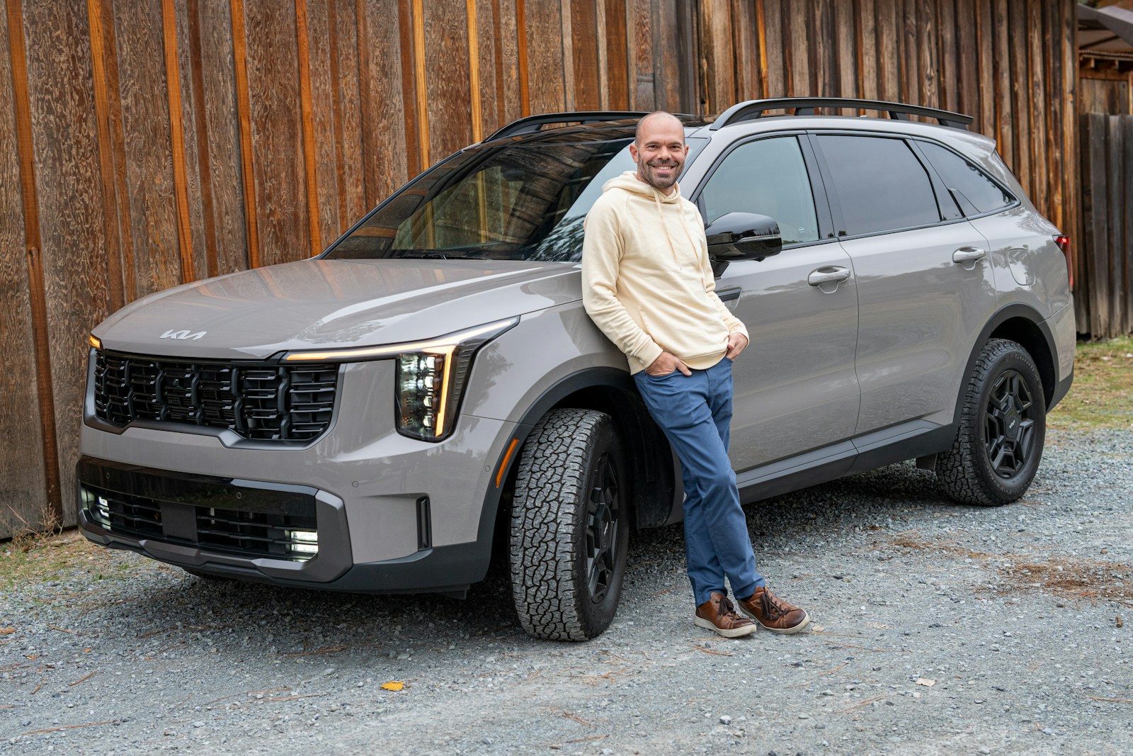 A man standing next to a gray suv