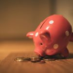 pink pig coin bank on brown wooden table