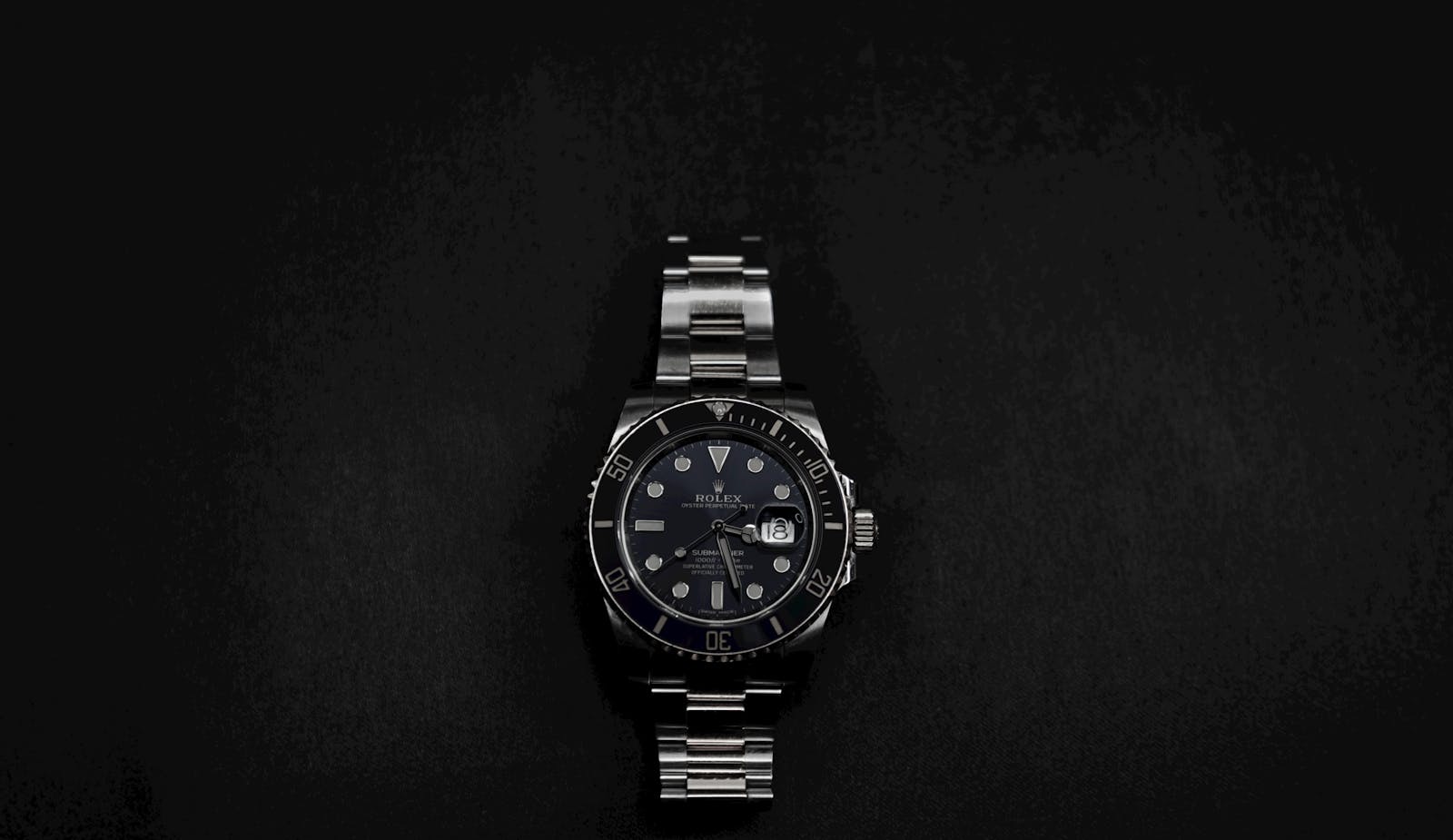 Close-up of an elegant Rolex wristwatch on a sleek black background.