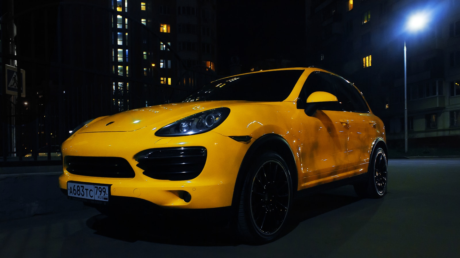 a yellow car parked on the street at night