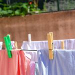 pink and white textiles hanged on brown wooden clothes hanger