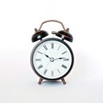 round black and white analog alarm clock