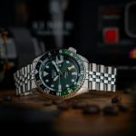 A watch sitting on top of a table next to a camera