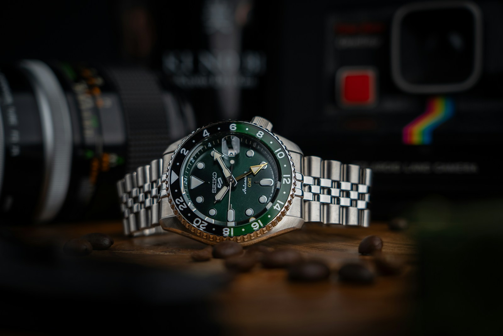 A watch sitting on top of a table next to a camera